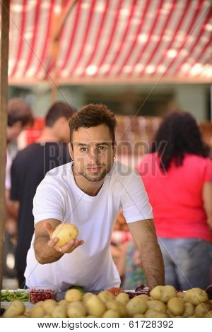 Farmer selling organic fruits and vegetables at an open street market.