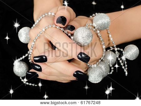Close up on beautiful female hand with black manicure.