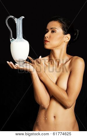 Nude woman is holding a ewer or yug of milk. Spa concept.