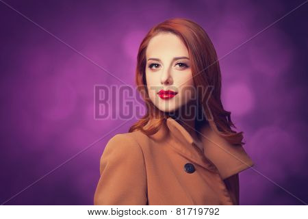 Redhead Women In Coat On Vilolet Background.
