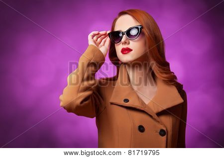 Redhead Women In Coat On Vilolet Background.