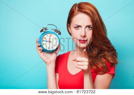 Redhead Girl With Alarm Clock On Blue Background.