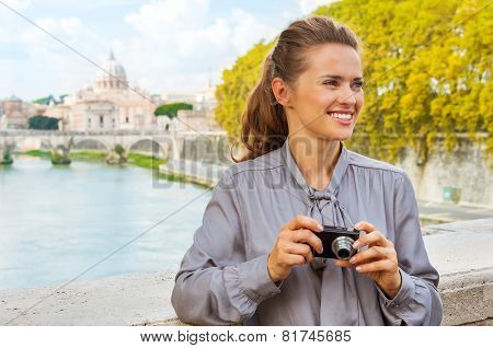 Portrait Of Happy Young Woman With Photo Camera While On Bridge