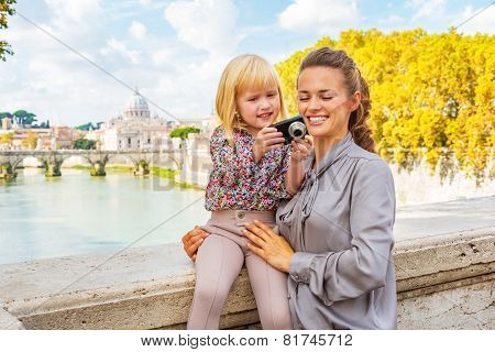 Mother And Baby Girl Checking Photos In Camera While On Bridge P