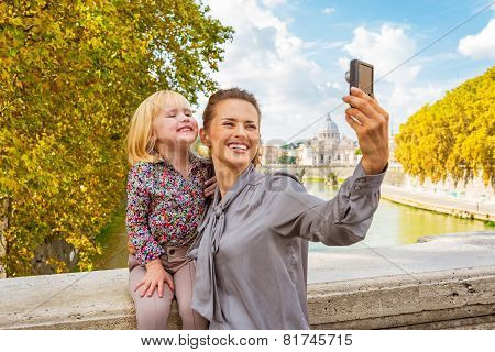 Happy Mother And Baby Girl Making Selfie On Bridge Ponte Umberto