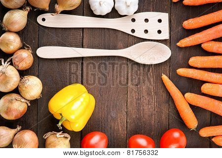 Fresh vegetables around the wooden kitchenware