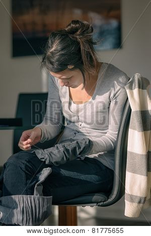 Young Mother Repairing Clothes