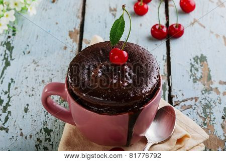chocolate cake in a mug on a wooden surface