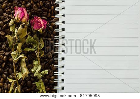 Notebook And Wizened Rose On Coffee Bean Background