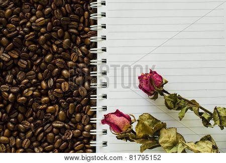 Notebook And Wizened Rose On Coffee Bean Background