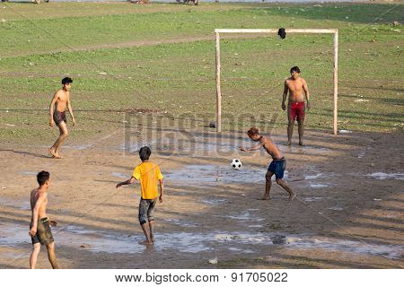 AMARAPURA, MYANMAR, JANUARY 18, 2015: Burmese young men are playing football near the Ubein bridge in Amarapura, Myanmar (Burma).