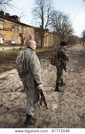 Two Armed Men Looking Around In The Village