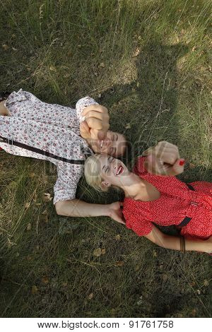 Man And Woman Lying On The Grass.