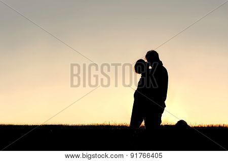 Silhouette Of Young Child Kissing Father On Cheek