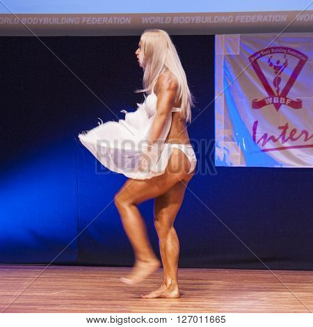 MAASTRICHT THE NETHERLANDS - OCTOBER 25 2015: Female fitness model Kinga Golebiewska flexes her muscles and shows her best physique in a dans act on stage at the World Grandprix Bodybuilding and Fitness of the WBBF-WFF on October 25 2015 at the MECC