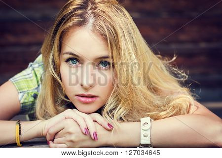 Romantic Portrait of a Hipster Fashion Girl at Wooden Background. Toned Photo with Copy Space.
