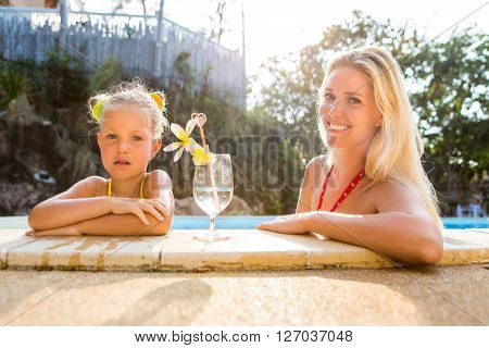 Cute Girl And Beautiful Mother At The Pool