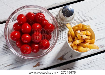 Tomatoes, fries and pepperbox. French fries with red tomatoes. Breakfast snack on white table. Vitamins and energy.
