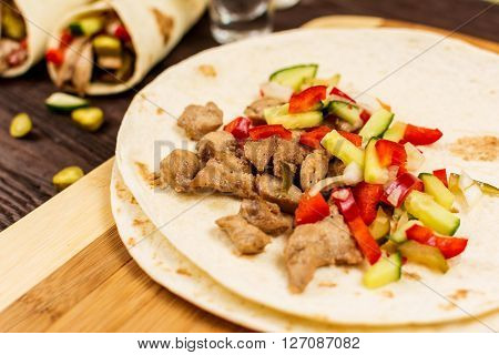 Traditional mexican tortila wrap with meat and vegetables