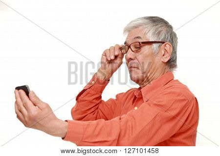 senior Japanese man with presbyopia on white background