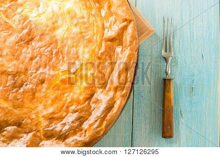 Cheese cake and one fork on over blue