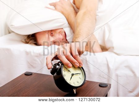 Man trying to sleep, when alarm clock ringing