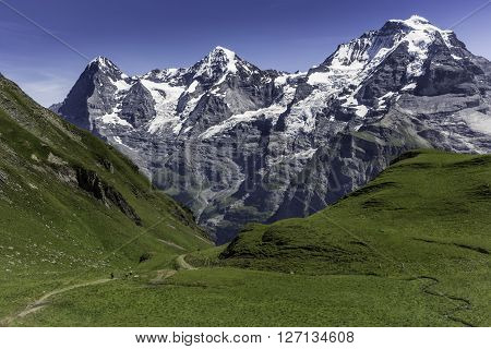 People hiking towards the famous three mountains in the Bernese Oberland in Switzerland