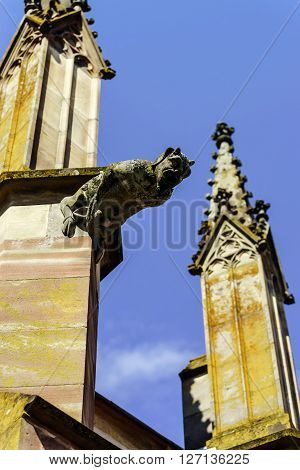 Gargoyle On A Gothic Cathedral, Detail Of A Tower On Blue Sky Background