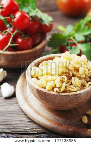 Sardinian uncooked pasta malloreddus with tomato selective focus