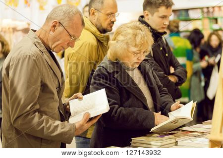 KYIV, UKRAINE - APR 21: Seniors reading new books with interest on the 6th International Festival BOOK ARSENAL on April 21, 2016. Guests of fair were Lars Svendsen Vigdis Hjorth Etgar Keret