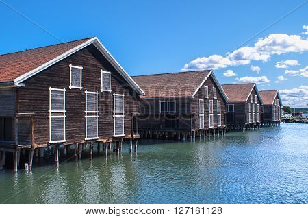 Old docks in Härnösand Sweden. Bright sky clear water