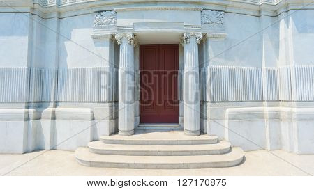 Classical design of ancient columns and wall with wood door.