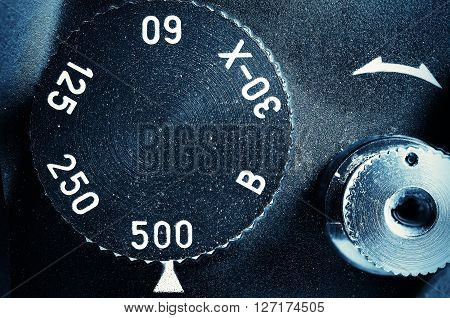 Fragment of old film camera. Top view dial of exposure and shutter button. Close up view. Macro. Selective focu. sVintage photo. Toning.