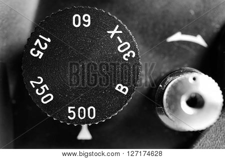 Fragment of old film camera. Top view dial of exposure and shutter button. Close up view. Macro. Selective focu. sVintage photo. Toning.