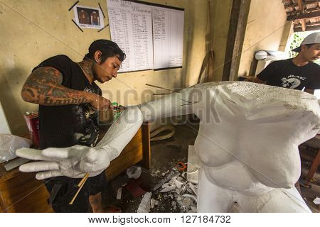 BALI, INDONESIA - FEB 24, 2016: Unidentified local people build Ogoh-ogoh statues for the Ngrupuk parade, which takes place on the eve of Nyepi day. Nyepi is a public holiday in Indonesia.