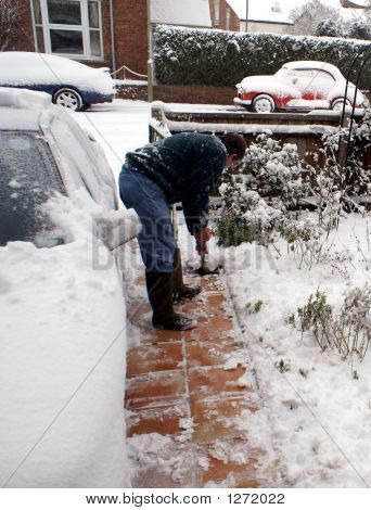 Um homem limpando a neve do caminho