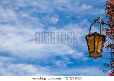 An ancient bronze lantern on a blue summer sky