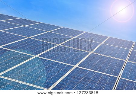 Solar panel with bright sun on blue sky