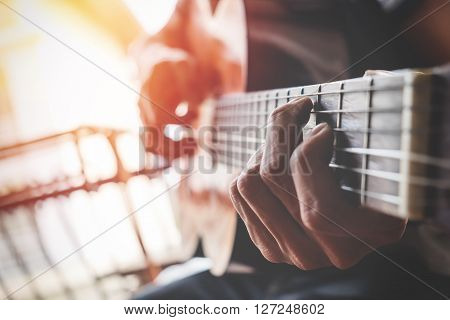 boys hand with a guitar on vintage effect.