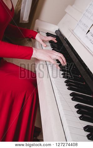 Hands and piano.Part of the body.hands on the white keys of the piano playing a melody.Women's hands on the keyboard of the pianoplaying the notes melody.Hands of young girlplays music on the piano