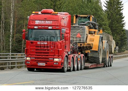 FORSSA, FINLAND - APRIL 23, 2016: Scania 164G transports heavy Volvo L350F wheel loader as wide load along road in South of Finland.