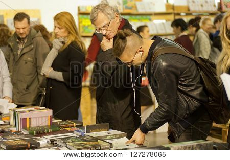 KYIV, UKRAINE - APR 21, 2016: Men of different generations reading books of the 6th International Festival BOOK ARSENAL on April 21, 2016. Guests of the fair were Lars Svendsen Vigdis Hjorth Etgar Keret