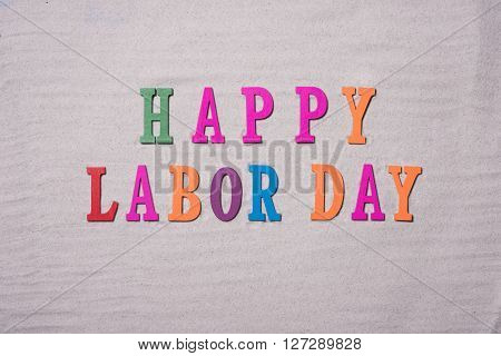 Happy Labor Day on the sandy beach background. Happy Labor Day word in colorful stones