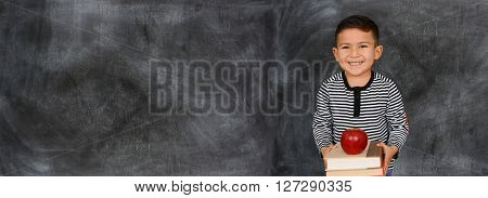 Young child who is standing with a chalkboard