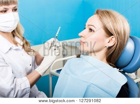 The reception was at the female dentist. Doctor examines the oral cavity on tooth decay. Caries protection. doctor puts the patient an anesthetic injection. close-up of the patient's mouth and squirt.