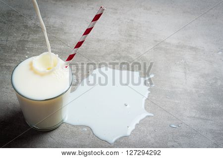 Milk Pouring Into Glass On A Concrete Table