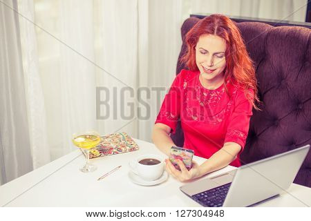 outdoor portrait of a young girl she works as a freelancer in a cafe drinking a delicious hot Cup of coffee from text send mail loads the photo instagram freelancer drinking cappuccino