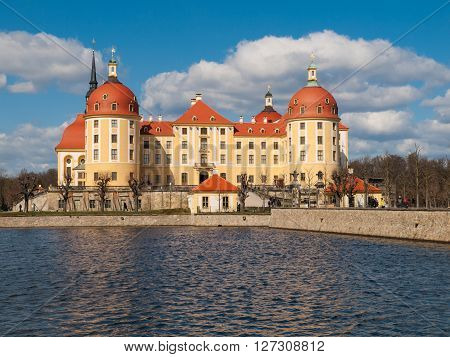 Baroque castle of Moritzburg with yellow facade and red roof on sunny day, Saxony, Germany