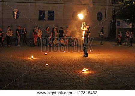 VINNYTSIA, UKRAINE - MAY 03, 2013: Fire juggler performs on European square in Vinnytsia, Ukraine