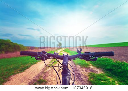 Mountain biking down hill descending fast on bicycle. View from bikers eyes
